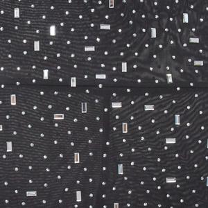 Detail of silver rhinestones and rectangular crystals on black mesh fabric dress