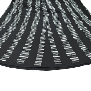 Detail view of the black fabric featuring a radial white dotted stripe pattern on the hem