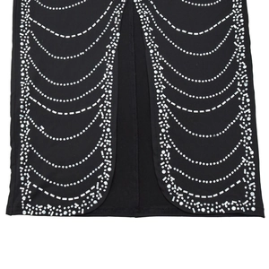 Detailed close-up of glittering rhinestone waves and crystal patterns on a black dress