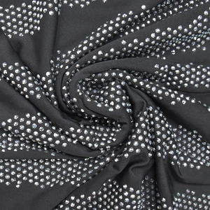 Macro shot of black stretch fabric with dense silver rhinestone crystal embellishments
