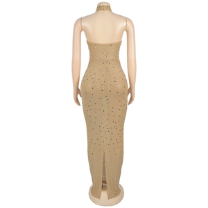 Detail of nude backless maxi dress with silver rhinestones and a back slit hemline