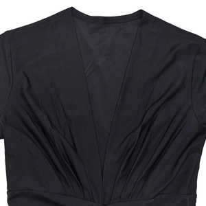 Detail of deep V-neckline with pleated design on black slim-fit stretch dress fabric