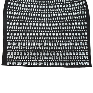 Détail des strass en cristal de formes variées sur l'ourlet d'une robe noire