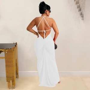 Detail of white backless dress featuring thin criss-cross straps and ruched waist fabric