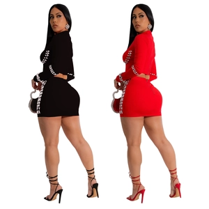 Detail of slim fit two-piece dress set with silver studs on red and black fabric
