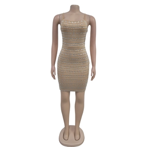 Détail de strass argentés et sequins horizontaux sur une robe de cocktail beige moulante