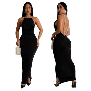 Detail of elegant backless black dress featuring luxury pearl chain straps on a slim fit maxi