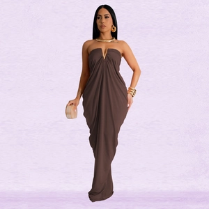 Detail of a brown floor-length dress featuring a gold V-shaped metal chest piece and draping