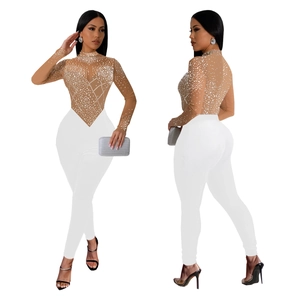 Detailed view of sheer mesh top with sparkling rhinestones and white skinny pants