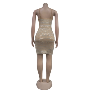 Gros plan du dos d'une mini robe moulante beige ornée de strass argentés brillants