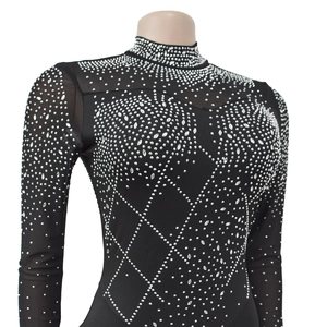 Close-up of black mesh jumpsuit featuring intricate rhinestone lattice and star patterns
