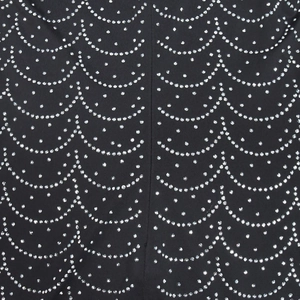 Vista macro di tessuto nero con strass argentati scintillanti in motivi a onde