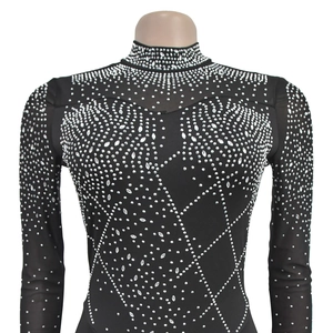 Detailed view of silver rhinestones in geometric pattern on black mesh bodysuit
