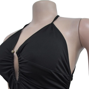 Close-up of black halter dress with deep V-neckline and gold bead detail on pleated fabric