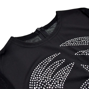 Detail of black dress with sheer mesh neckline and intricate silver rhinestone patterns