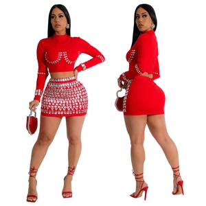 Detail view of red two-piece dress set with silver rhinestones and long sleeves
