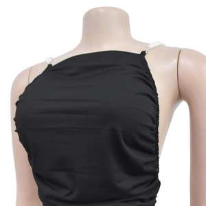 Detailed close-up of the black backless top featuring elegant white pearl bead straps