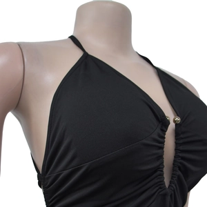 Detail of a black halter neck dress featuring a deep V-neckline and gold bead accents