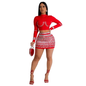 Close-up of red two-piece party set featuring intricate silver rhinestone patterns on fabric