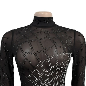 Dettaglio del top in rete nera trasparente con strass geometrici e collo a lupetto
