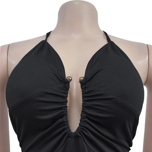 Detail of black halter top with deep V-neck, ruched fabric and gold bead accents