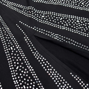 Detail of silver rhinestones on black dress fabric with elegant side slit design