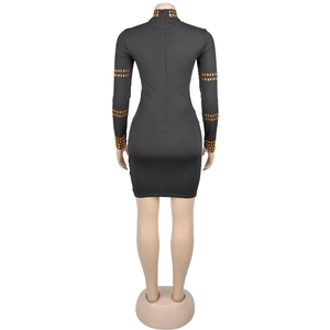 Détail de la mini robe moulante noire avec strass orange et fermeture éclair dans le dos