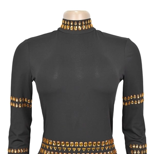Détail de strass orange sur le col et la taille d'une robe moulante noire élégante