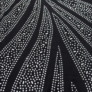 Macro view of silver rhinestones in radial pattern on black tight bodycon dress fabric