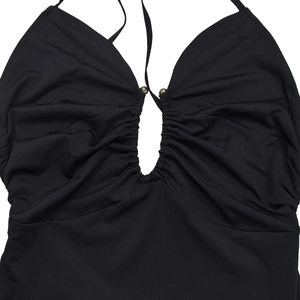 Detail of black halter dress featuring ruched chest with drop-shaped cutout and gold beads