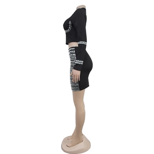 Detail view of shimmering silver rhinestones on black long sleeve crop top and mini skirt set