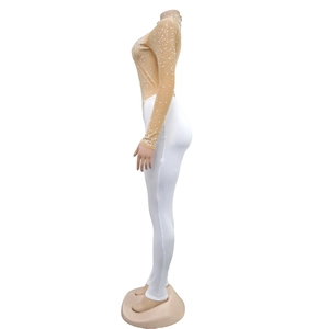 Detailed side view of flesh-colored mesh top with rhinestones and white tight pants