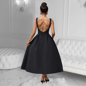Detail of elegant black backless dress showing deep U-shaped back and pleated wide skirt