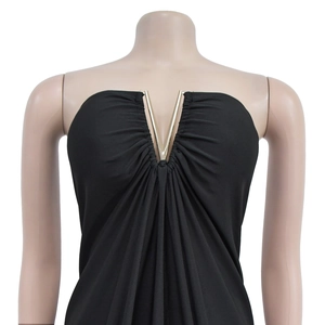 Close-up of black V-neck dress with decorative gold metal hardware and ruched fabric detail