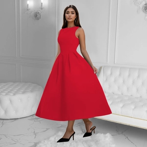 Detail of red sleeveless French retro dress showing waist pleats and flare hemline