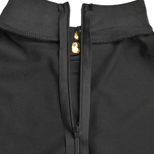 Détail de la robe noire à col montant avec fermeture éclair et pierres jaunes serties