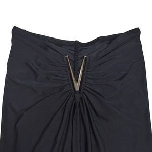 Detail of elegant black dress showing a silver metal V-shaped buckle and ruched fabric texture