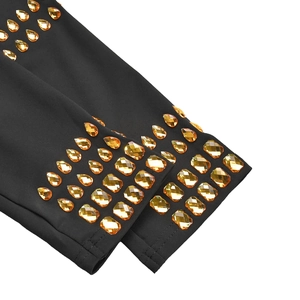 Détail de strass ambrés en forme de goutte et de rectangle sur tissu de robe noir ajusté