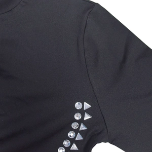 Close-up of black knit fabric sleeve featuring sparkling round and triangular rhinestone trim