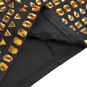 Détail rapproché de strass orange vif sur le tissu d'une robe en tricot noir