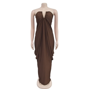 Detailed view of the V-shaped metallic ornament and draped pleats on this brown maxi dress