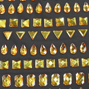 Détail des strass ambrés facettés aux formes géométriques sur tissu noir élégant