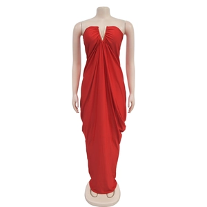 Detail of red floor-length evening dress with V-neck metal accent and ruched fabric texture