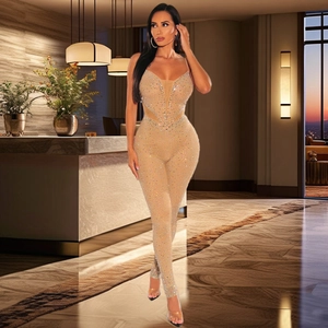Detail eines champagnerfarbenen Strass-Jumpsuits mit dünnen Trägern und Netz-V-Ausschnitt