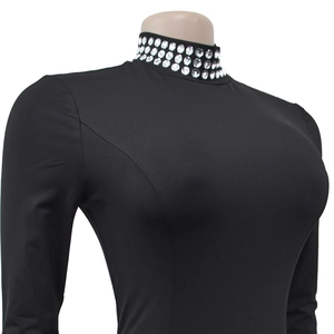 Close-up of sparkling large white rhinestones on the high neck of a black slim-fit dress