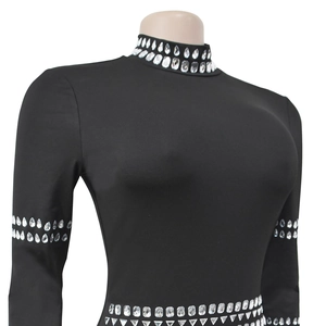 Vue détaillée des strass argentés sur la robe noire moulante avec des manches longues