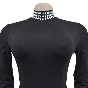 Close-up of sparkling rhinestone trim on high-neck black slim fit long sleeve dress