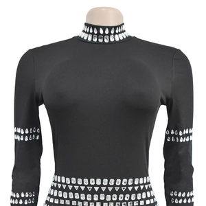 Détail de la robe noire moulante avec strass géométriques sur le col et la taille