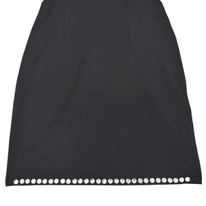 Detail of black slim dress hem featuring neatly arranged silver rhinestone embellishments