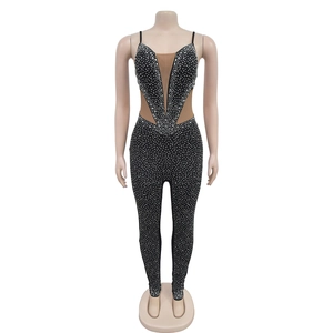 Detailaufnahme des schwarzen Jumpsuits mit Strasssteinen und tiefem V-Ausschnitt